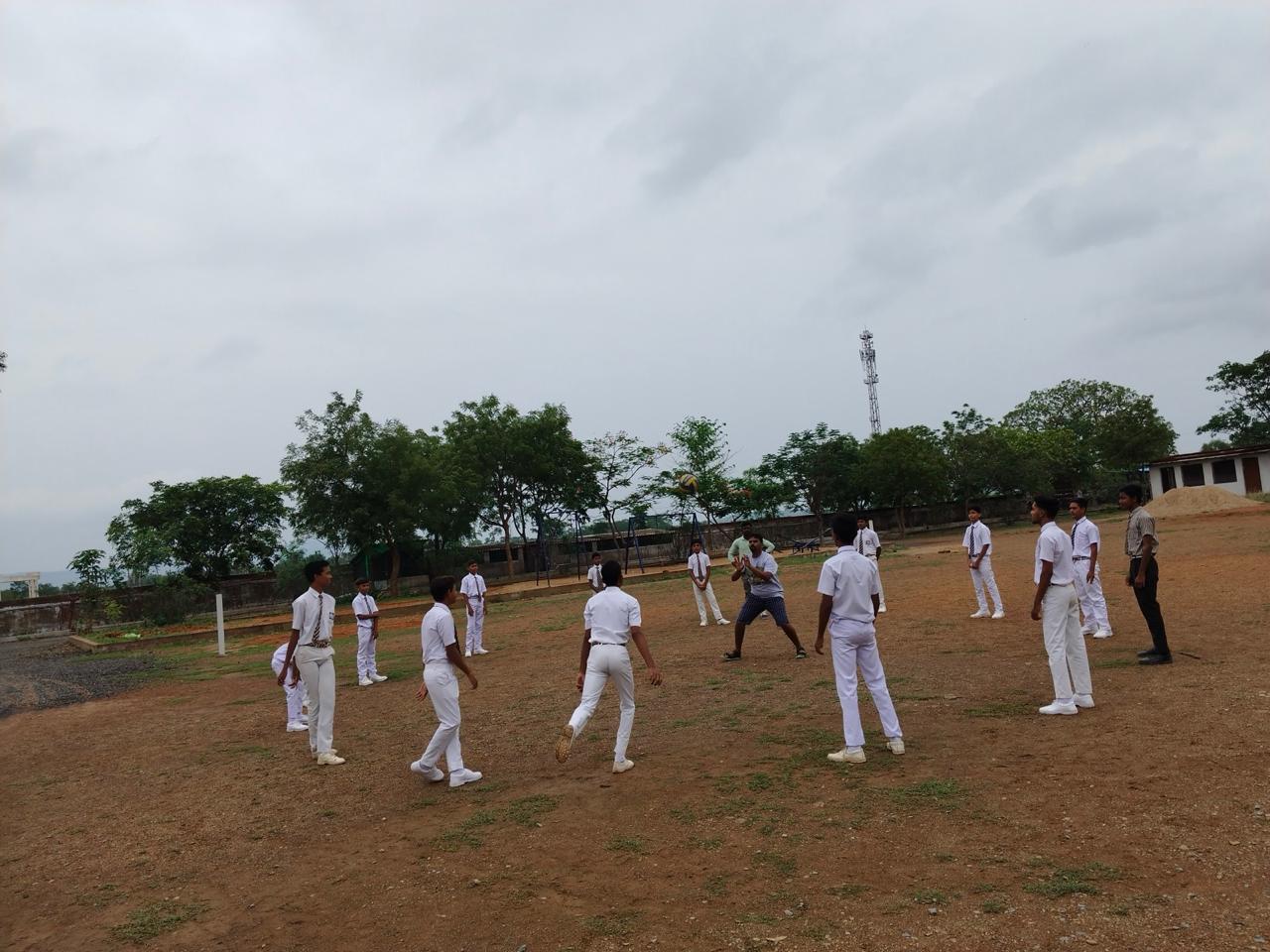 Students playing volleyball on the sports ground at Carmel school